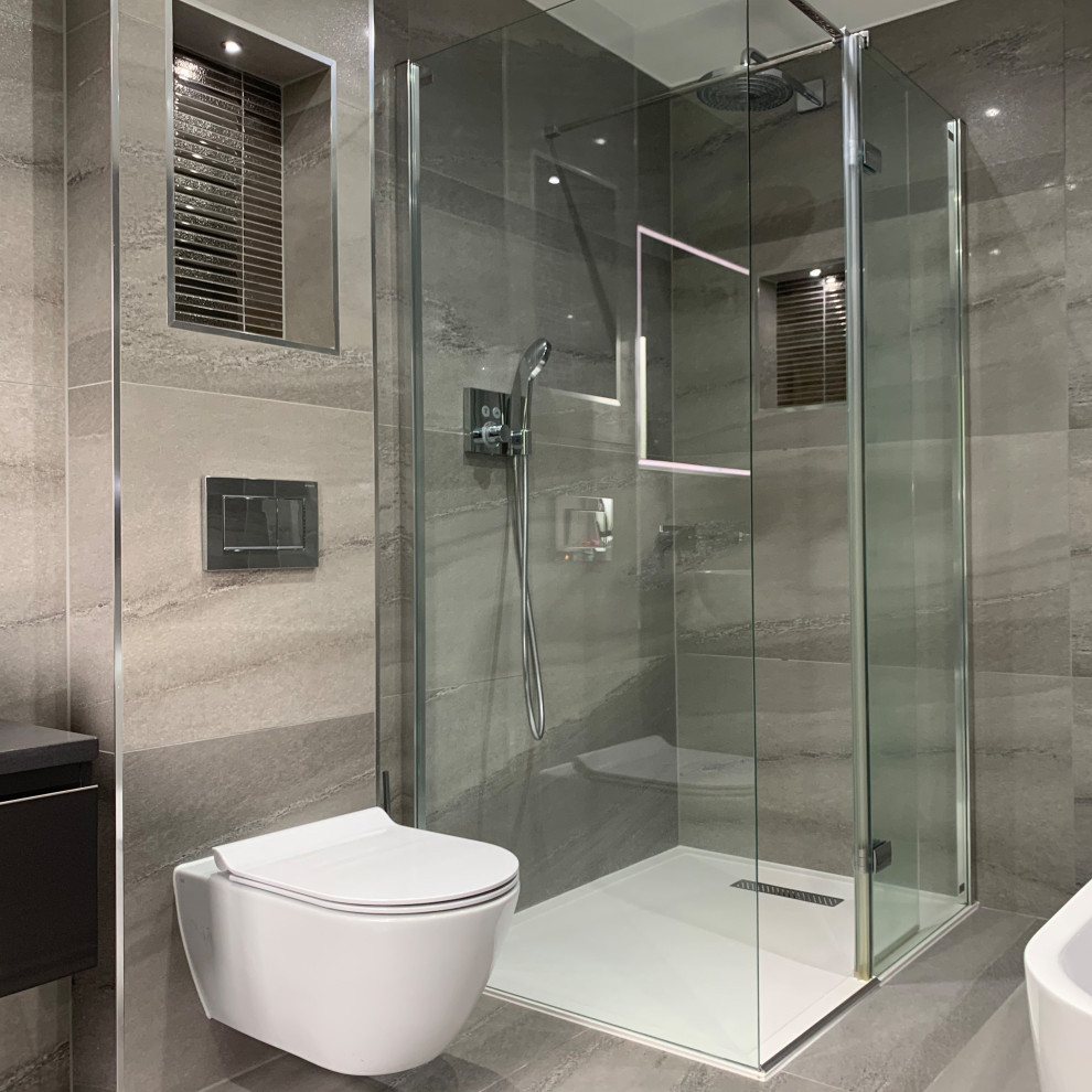 Large trendy master gray tile and porcelain tile porcelain tile, gray floor and double-sink bathroom photo in London with flat-panel cabinets, gray cabinets, a wall-mount toilet, gray walls, a vessel sink, quartzite countertops, black countertops and a floating vanity