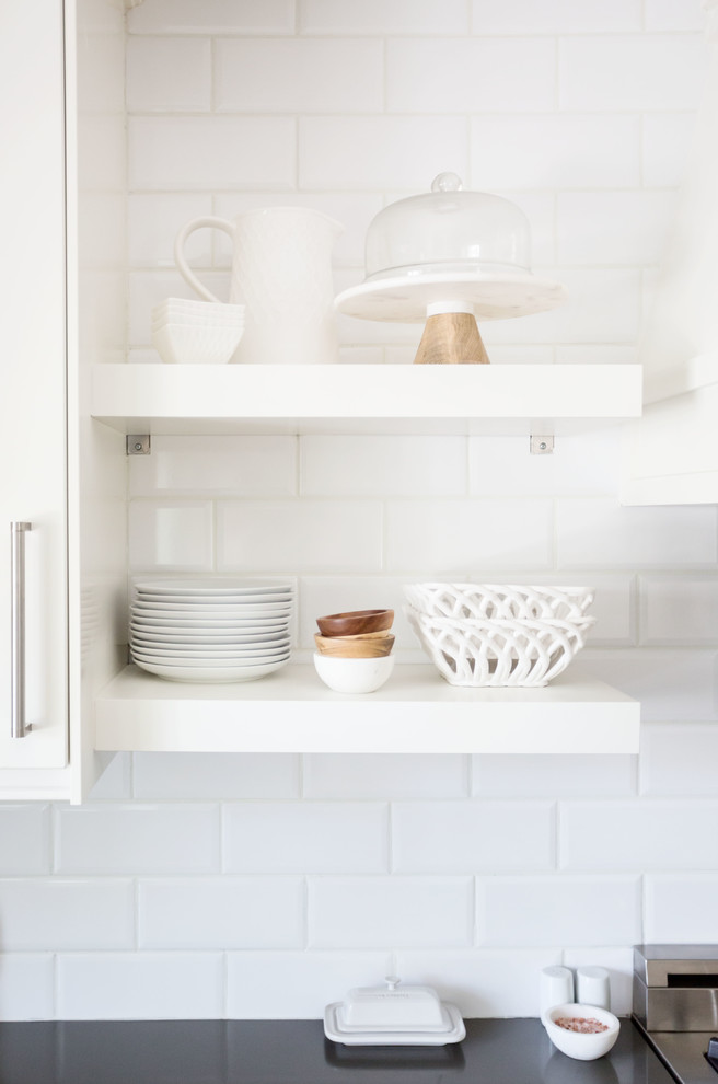 Large transitional u-shaped light wood floor and brown floor eat-in kitchen photo in Phoenix with a farmhouse sink, recessed-panel cabinets, white cabinets, quartz countertops, white backsplash, subway tile backsplash, stainless steel appliances, an island and white countertops