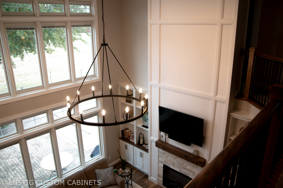 Inspiration for a large transitional l-shaped laminate floor and brown floor open concept kitchen remodel with an undermount sink, flat-panel cabinets, white cabinets, quartz countertops, white backsplash, ceramic backsplash, stainless steel appliances, an island and white countertops
