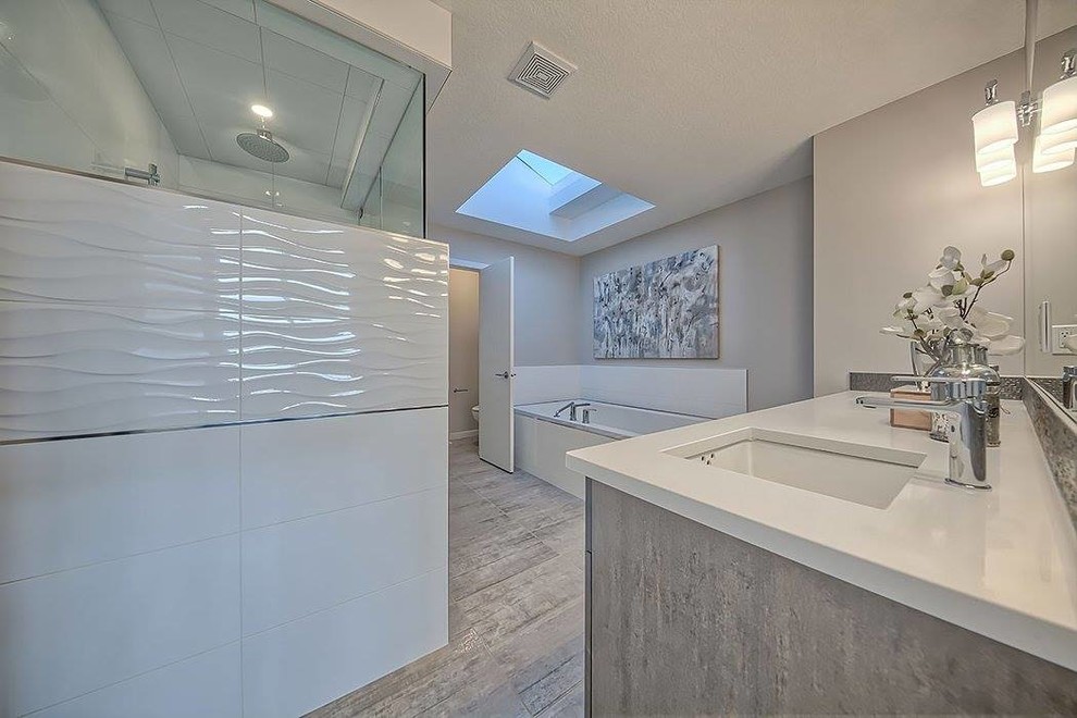 Design ideas for a large contemporary master bathroom in Calgary with flat-panel cabinets, grey cabinets, a drop-in tub, a corner shower, grey walls, plywood floors, an undermount sink and engineered quartz benchtops.