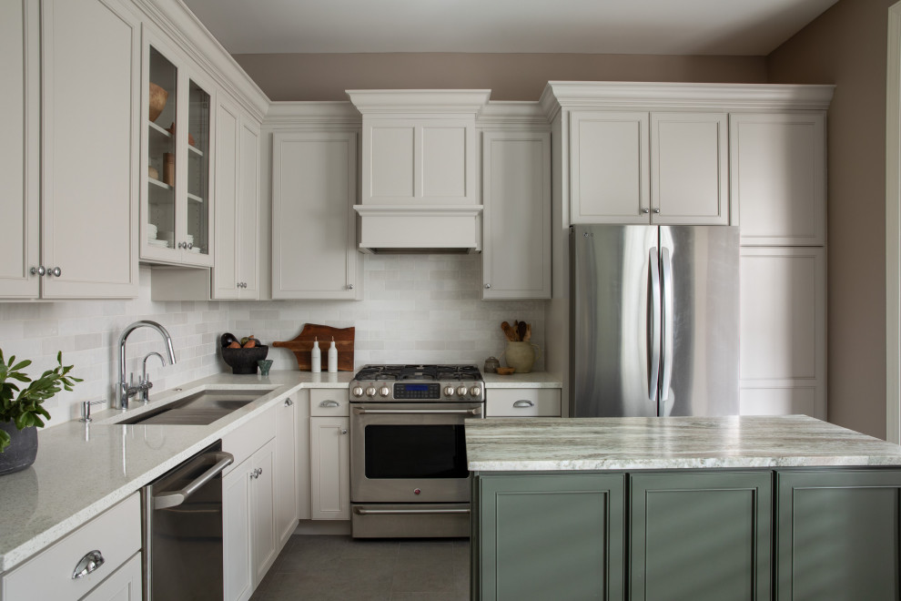 Huge u-shaped porcelain tile and gray floor kitchen pantry photo with a drop-in sink, recessed-panel cabinets, beige cabinets, white backsplash, ceramic backsplash, stainless steel appliances, an island and white countertops
