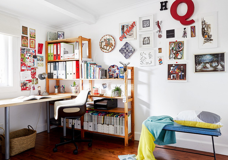 This is an example of a small eclectic home office in Melbourne with white walls and dark hardwood floors.