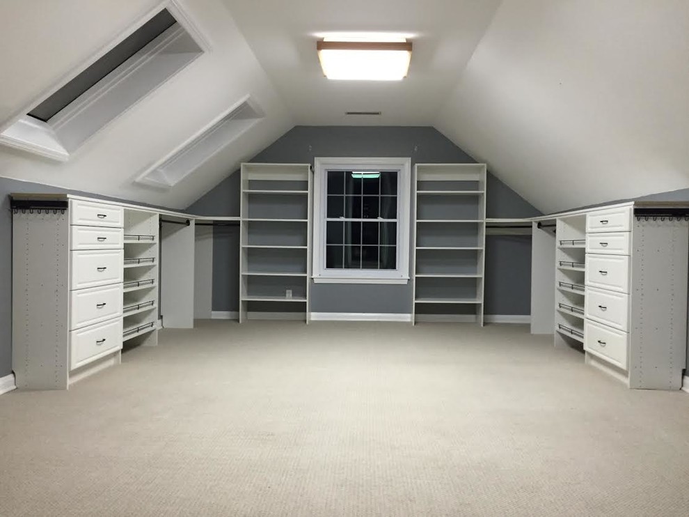 Large modern gender-neutral walk-in wardrobe in Huntington with raised-panel cabinets, white cabinets, carpet and beige floor.