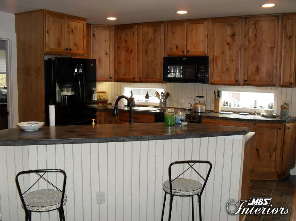 Eat-in kitchen - rustic l-shaped eat-in kitchen idea with a double-bowl sink, shaker cabinets, medium tone wood cabinets, solid surface countertops, white backsplash and black appliances