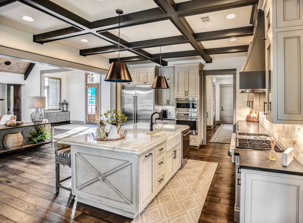 Design ideas for a large transitional l-shaped open plan kitchen in Other with a farmhouse sink, shaker cabinets, beige cabinets, marble benchtops, white splashback, ceramic splashback, stainless steel appliances, dark hardwood floors, with island, brown floor, white benchtop and coffered.