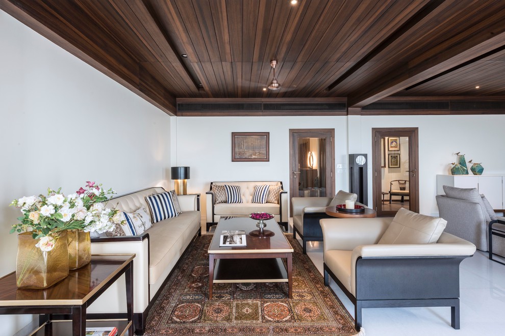 This is an example of an asian formal open concept living room in Mumbai with white walls and white floor.