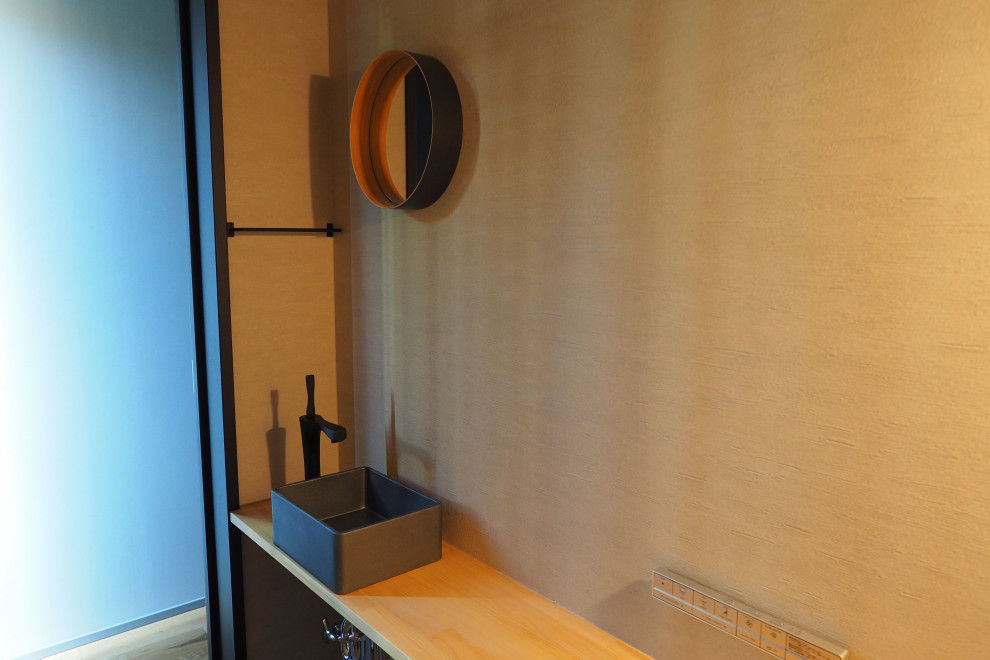 Bild på ett toalett, med grå väggar, plywoodgolv och grått golv