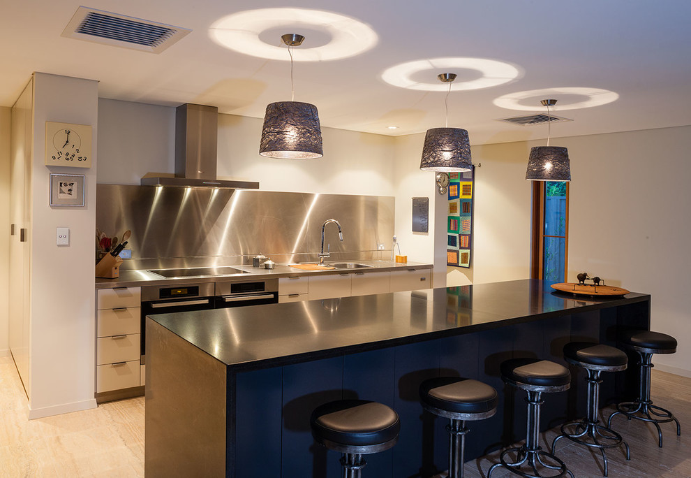 Inspiration for a mediterranean galley eat-in kitchen in Perth with flat-panel cabinets, stainless steel cabinets, quartz benchtops, metallic splashback, stainless steel appliances, travertine floors and with island.