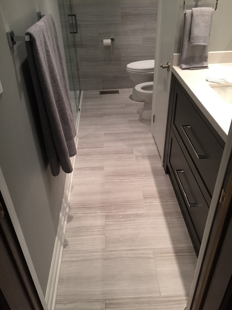 Mid-sized transitional 3/4 bathroom in Toronto with shaker cabinets, black cabinets, an alcove shower, a bidet, gray tile, ceramic tile, grey walls, ceramic floors, an undermount sink, engineered quartz benchtops, grey floor and a hinged shower door.