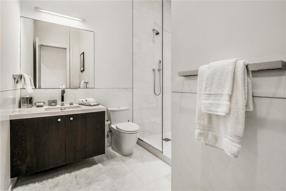 Design ideas for a modern bathroom with dark wood cabinets, marble benchtops, an open shower, white tile, a one-piece toilet, marble floors, an undermount sink, white floor, a hinged shower door, white benchtops, marble and white walls.