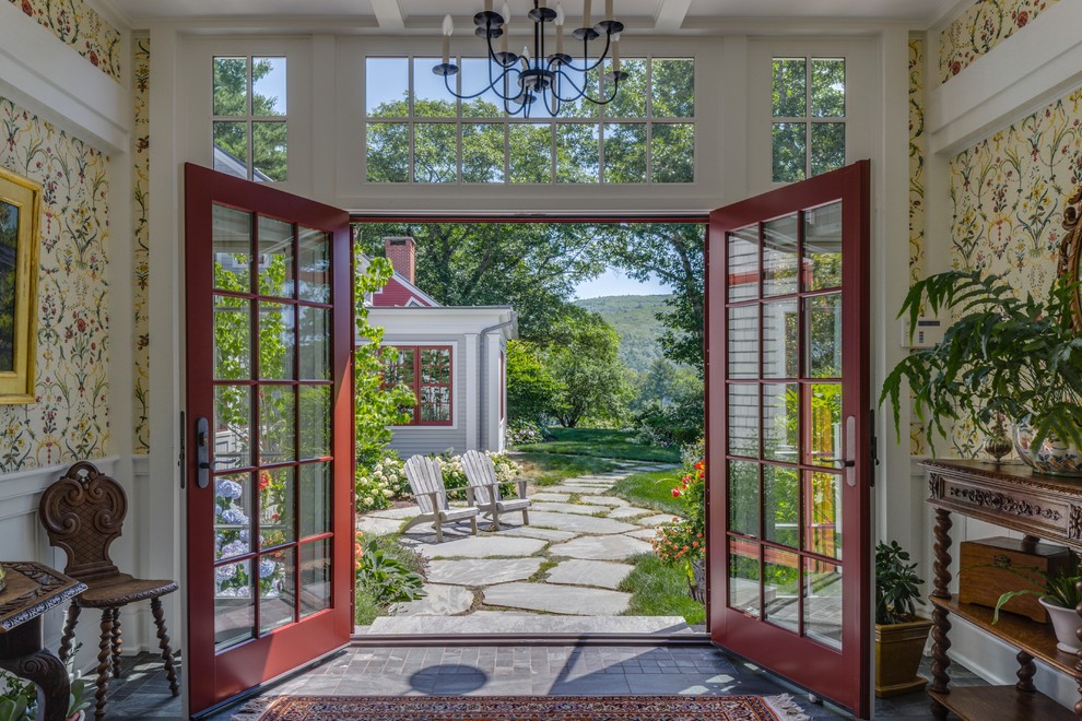 This is an example of a large country entryway in Portland Maine with beige walls, a double front door, a glass front door and grey floor.