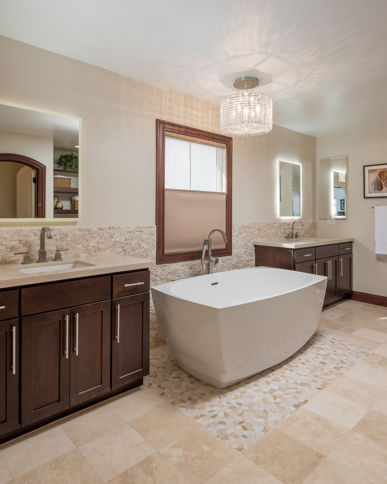 Design ideas for an expansive modern master bathroom in San Diego with recessed-panel cabinets, dark wood cabinets, a freestanding tub, an alcove shower, a two-piece toilet, beige tile, ceramic tile, beige walls, travertine floors, a drop-in sink and engineered quartz benchtops.