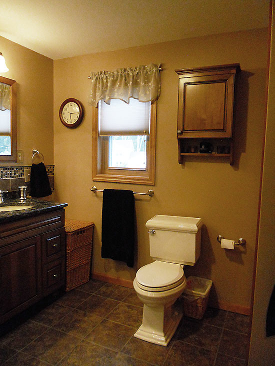 Photo of a mid-sized transitional master bathroom in Boston with an undermount sink, shaker cabinets, dark wood cabinets, brown tile, a drop-in tub, an alcove shower, a two-piece toilet, ceramic floors, engineered quartz benchtops and orange walls.