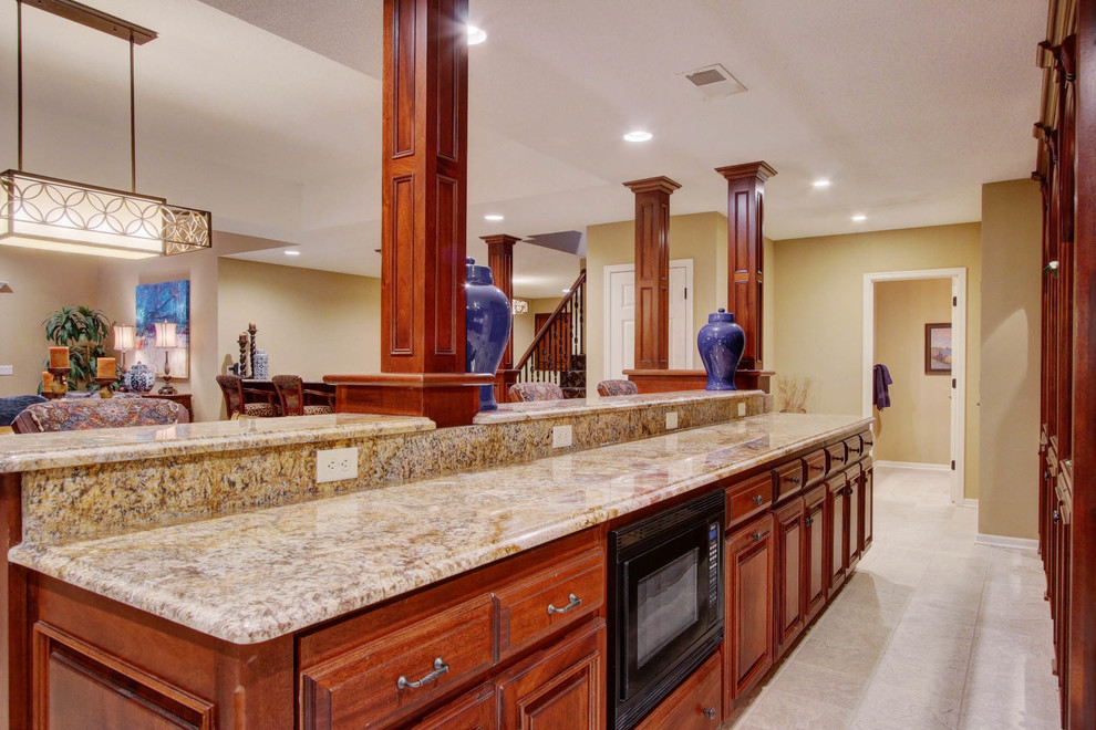Large transitional galley wet bar in Kansas City with raised-panel cabinets, dark wood cabinets, granite benchtops, white splashback and carpet.