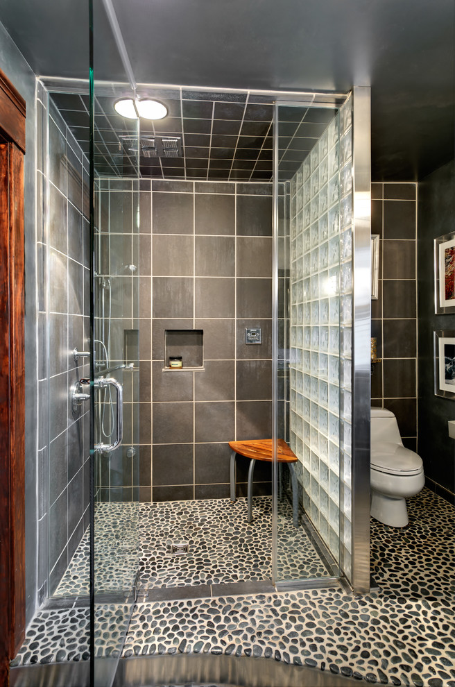 Mid-sized eclectic master bathroom in Philadelphia with open cabinets, pebble tile, grey walls, pebble tile floors, an undermount sink, glass benchtops, an alcove shower, a one-piece toilet, black tile and gray tile.