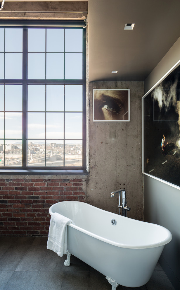This is an example of an industrial master bathroom in Denver with a claw-foot tub.