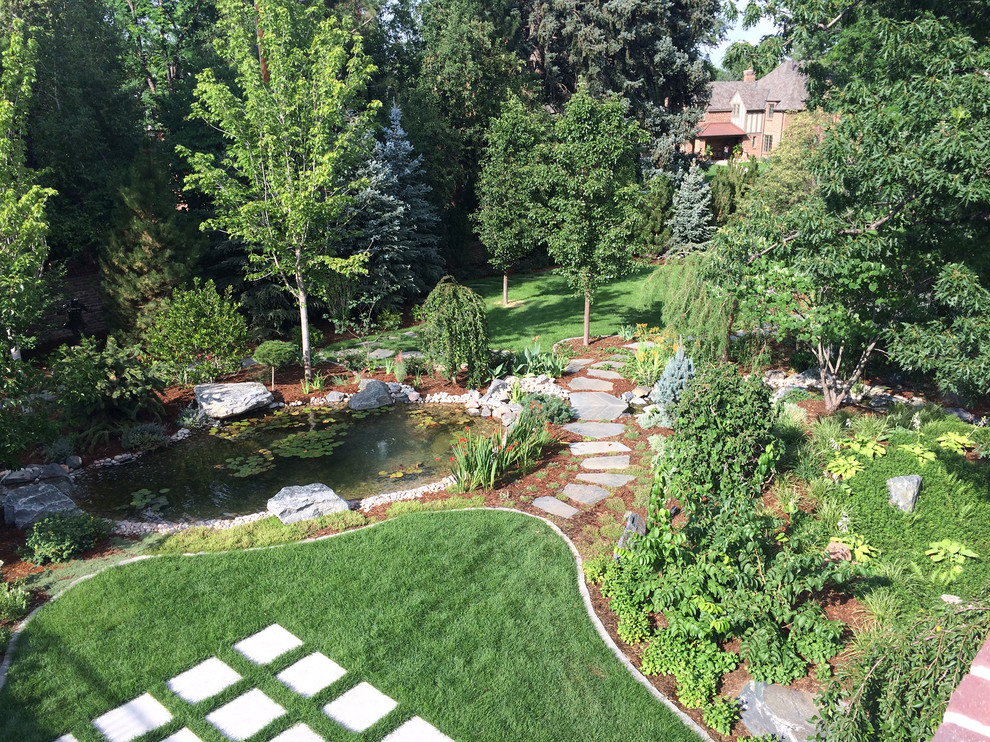 Design ideas for a large traditional backyard full sun xeriscape in Denver with with pond and natural stone pavers.