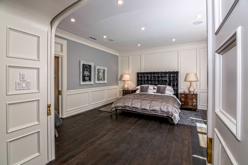 Large modern master bedroom in Los Angeles with grey walls, dark hardwood floors and no fireplace.