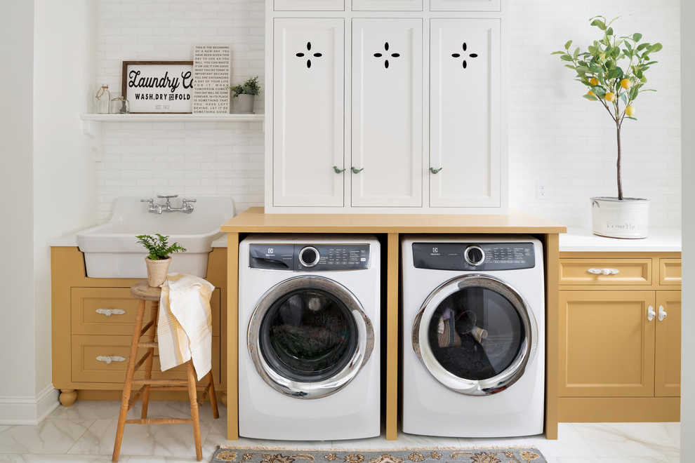 Design ideas for a mid-sized country single-wall utility room in Minneapolis with a drop-in sink, beaded inset cabinets, yellow cabinets, a side-by-side washer and dryer, white floor and yellow benchtop.