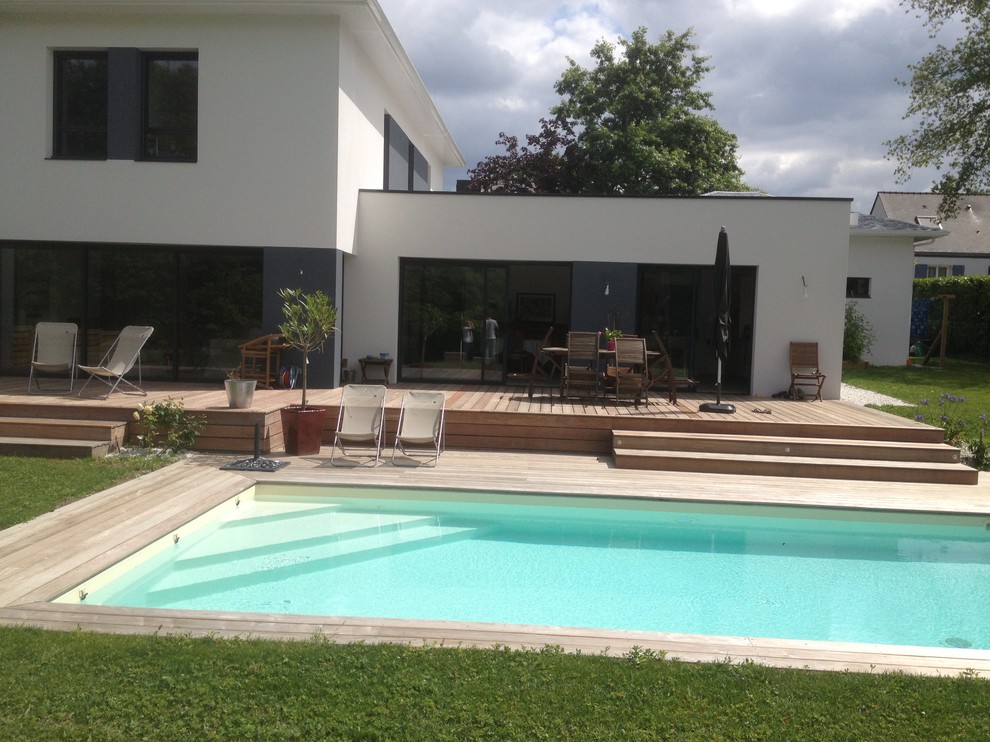 Cette image montre un couloir de nage arrière design de taille moyenne et rectangle avec une terrasse en bois.