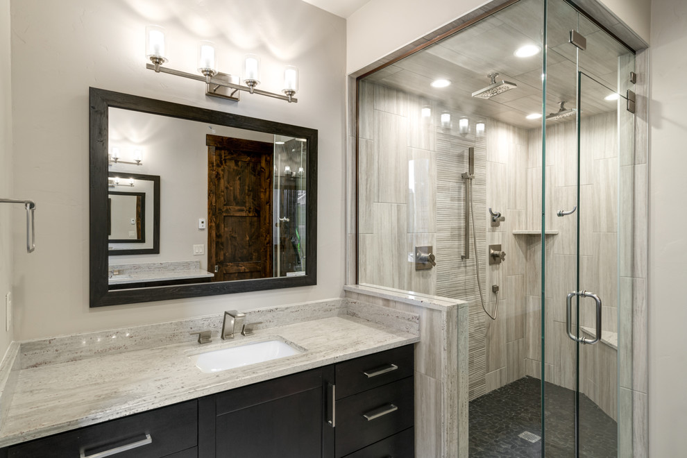 Inspiration for a mid-sized contemporary master bathroom in Denver with recessed-panel cabinets, black cabinets, a double shower, gray tile, ceramic tile, white walls, ceramic floors, an undermount sink, granite benchtops, grey floor, a hinged shower door and white benchtops.