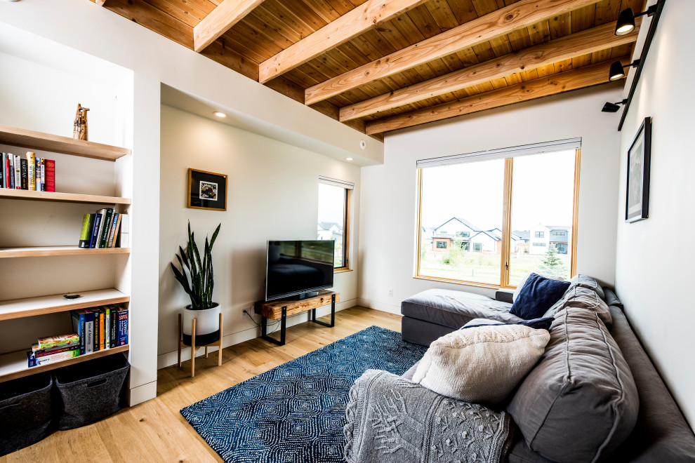 Immagine di un soggiorno design di medie dimensioni e stile loft con libreria, pareti bianche, parquet chiaro, TV a parete, pavimento bianco e soffitto in legno