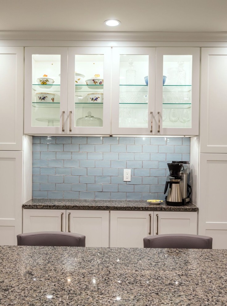 Inspiration for a mid-sized transitional u-shaped porcelain tile eat-in kitchen remodel in Orange County with an undermount sink, shaker cabinets, white cabinets, granite countertops, blue backsplash, glass tile backsplash, stainless steel appliances and an island