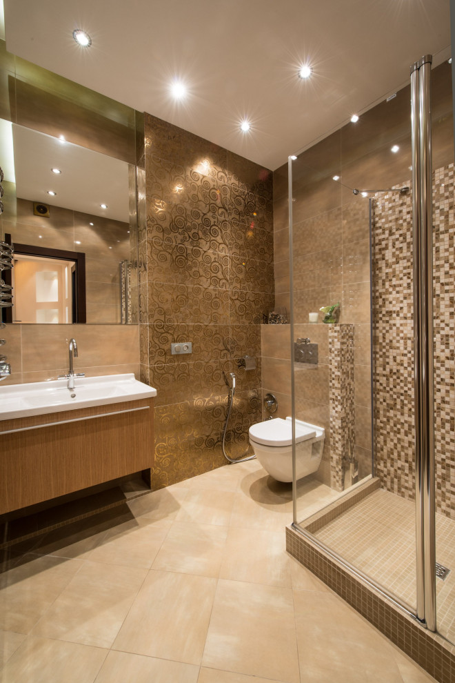 This is an example of a large contemporary 3/4 bathroom in Moscow with flat-panel cabinets, medium wood cabinets, a corner shower, a wall-mount toilet, brown tile, porcelain floors, an integrated sink, beige floor, a hinged shower door, white benchtops and a freestanding vanity.