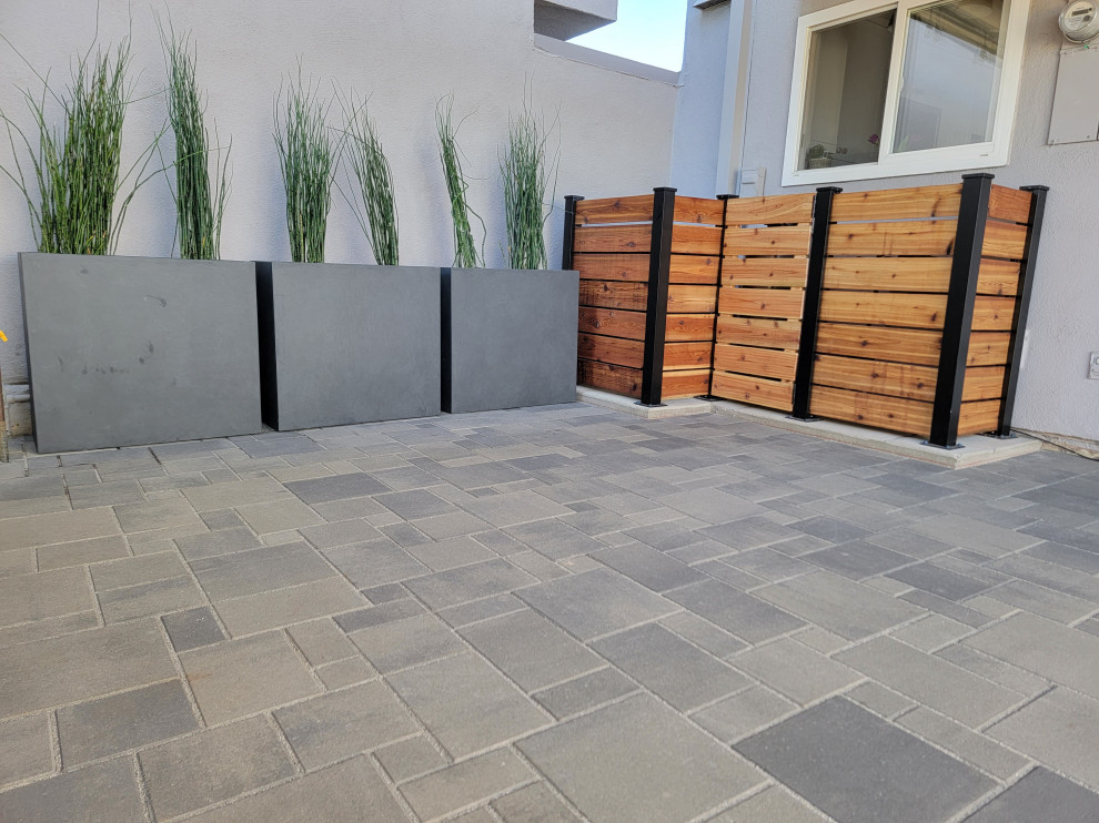 Example of a mid-sized minimalist backyard concrete paver patio design in Orange County with no cover