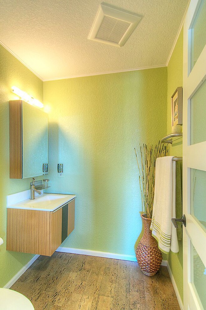 Design ideas for a small contemporary powder room in Seattle with flat-panel cabinets, brown cabinets, green walls, cork floors and an integrated sink.