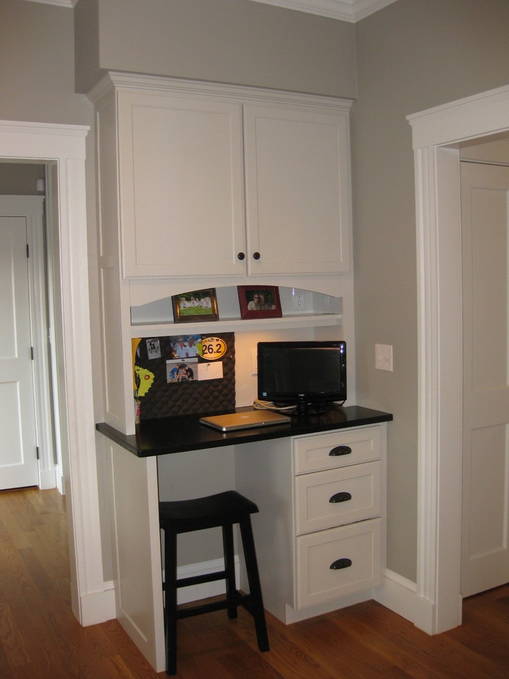 Eat-in kitchen - transitional l-shaped medium tone wood floor eat-in kitchen idea in Boston with an undermount sink, shaker cabinets, white cabinets, granite countertops, white backsplash, ceramic backsplash, stainless steel appliances, an island and black countertops