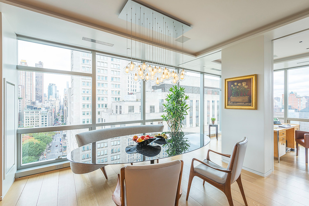 Inspiration for a contemporary dining room in New York with white walls and light hardwood floors.