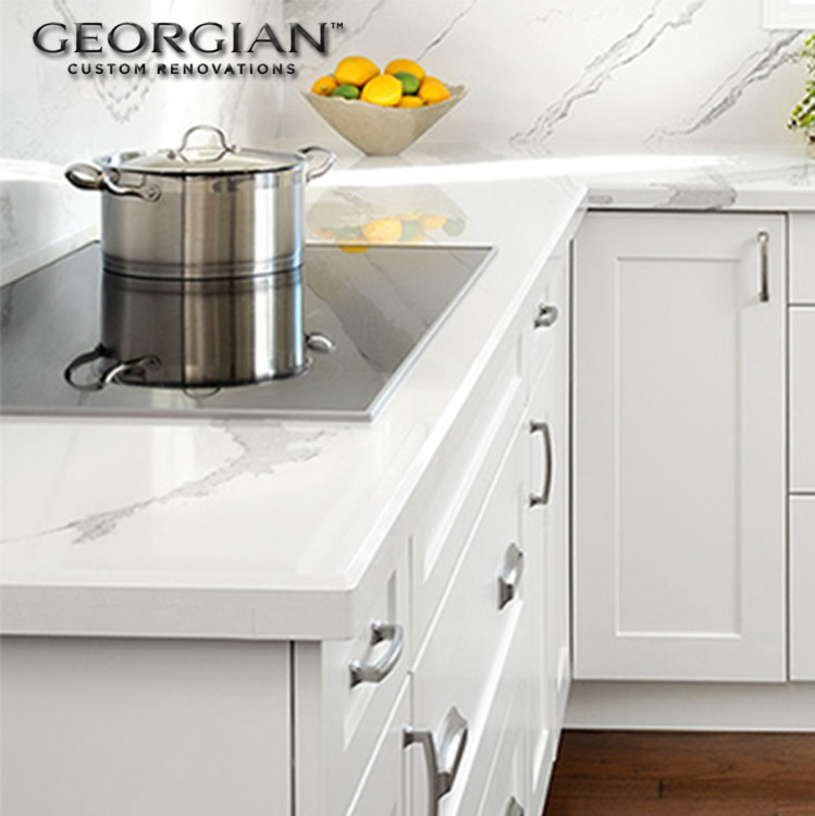 Small transitional l-shaped medium tone wood floor kitchen photo with an undermount sink, shaker cabinets, white cabinets, quartzite countertops, white backsplash, stone slab backsplash, stainless steel appliances and an island