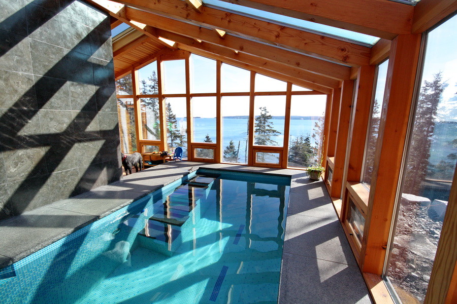 Inspiration for a large country indoor rectangular lap pool in Portland Maine with concrete pavers.