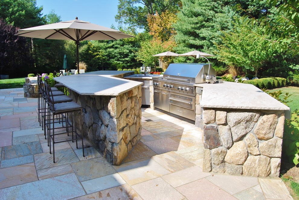 Inspiration for a mid-sized traditional backyard patio in New York with an outdoor kitchen, natural stone pavers and no cover.