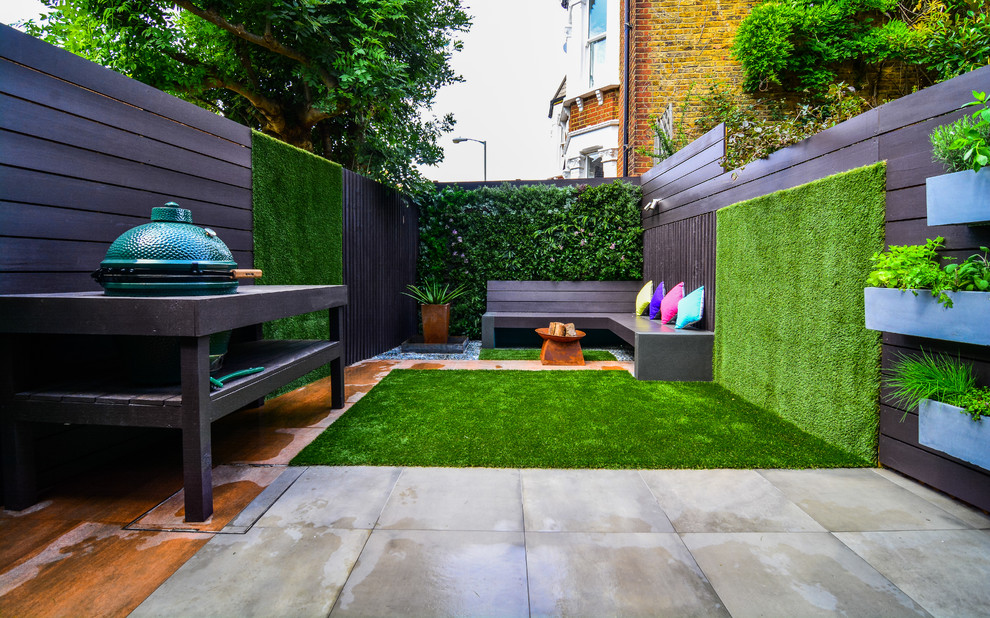 Design ideas for a contemporary backyard patio in London with a vertical garden, concrete pavers and no cover.