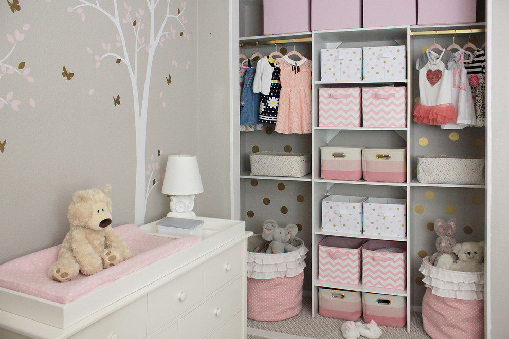 This is an example of a small nursery for girls in Los Angeles with grey walls, carpet and beige floor.