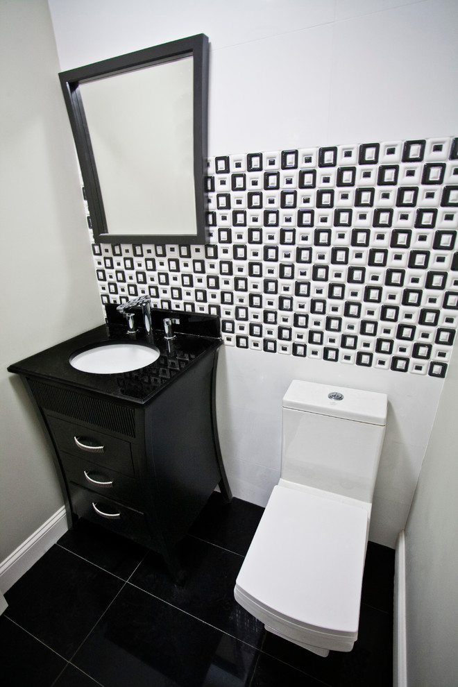 Inspiration for a small contemporary powder room in New York with an undermount sink, recessed-panel cabinets, black cabinets, engineered quartz benchtops, a two-piece toilet, black and white tile, ceramic tile, green walls, ceramic floors and black floor.
