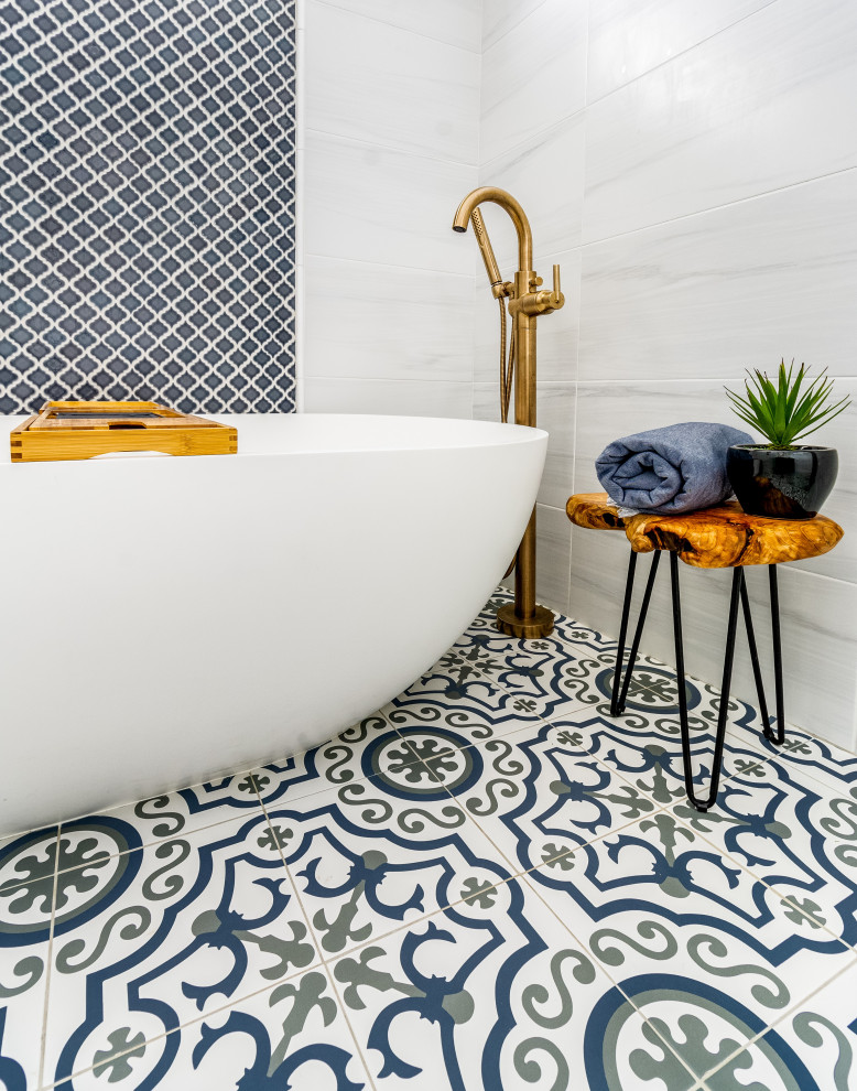 Mid-sized transitional master gray tile and ceramic tile ceramic tile, blue floor and double-sink bathroom photo in New York with shaker cabinets, blue cabinets, a two-piece toilet, white walls, an undermount sink, marble countertops, yellow countertops and a freestanding vanity