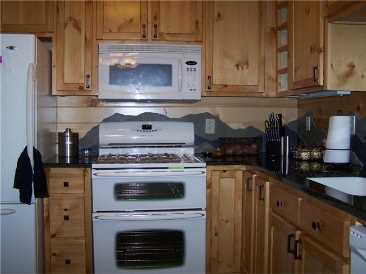 Inspiration for a mid-sized rustic u-shaped porcelain tile open concept kitchen remodel in Chicago with an undermount sink, shaker cabinets, light wood cabinets, granite countertops, gray backsplash, porcelain backsplash, white appliances and a peninsula