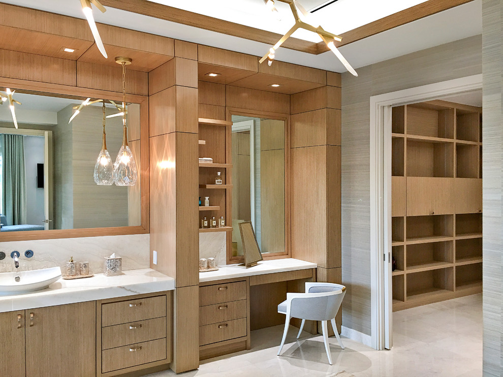 This is an example of an expansive transitional master bathroom in Miami with flat-panel cabinets, light wood cabinets, a freestanding tub, a double shower, marble floors, a vessel sink, onyx benchtops and beige floor.