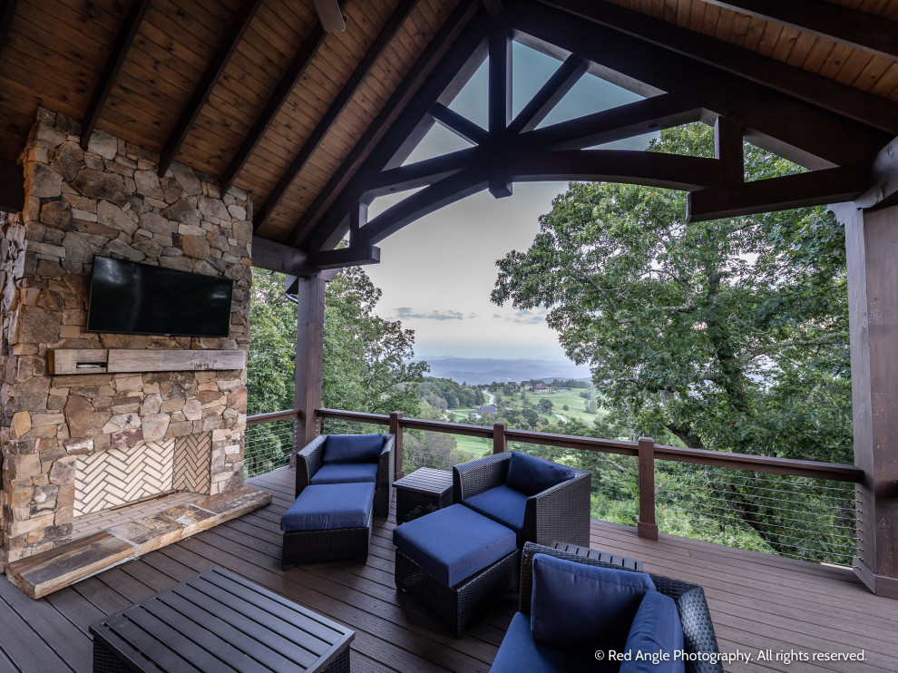 Mid-sized mountain style backyard second story cable railing deck photo with a fireplace and a roof extension