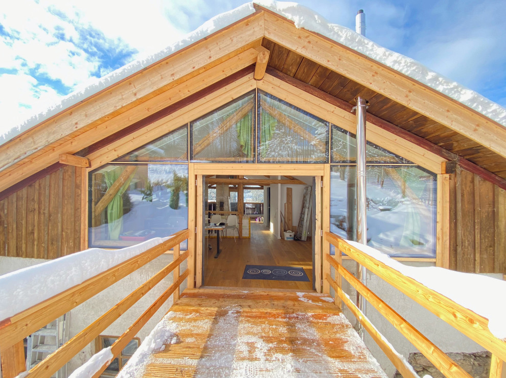 Große, Überdachte Landhausstil Terrasse hinter dem Haus mit Holzgeländer und Verkleidung in München