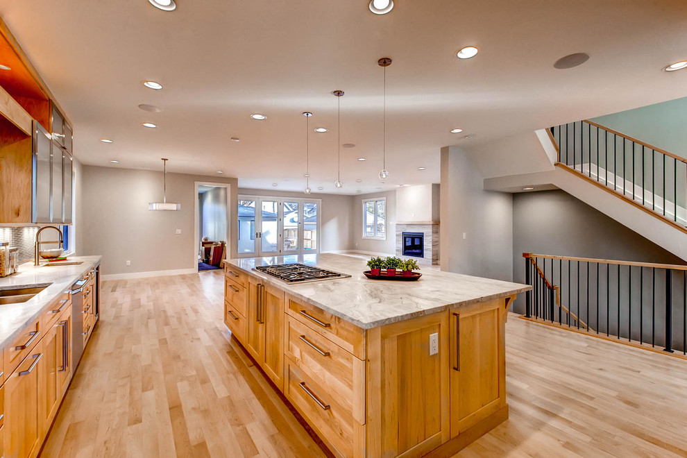 Inspiration for an expansive contemporary l-shaped open plan kitchen in Denver with an undermount sink, glass-front cabinets, light wood cabinets, quartz benchtops, grey splashback, ceramic splashback, stainless steel appliances, light hardwood floors and with island.