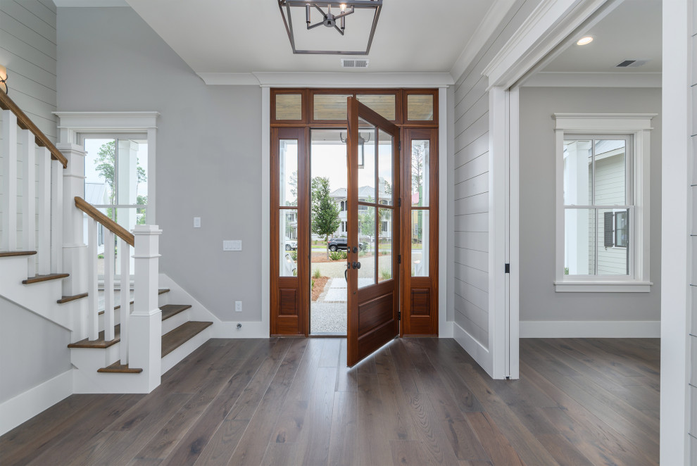 Example of a transitional brown floor and shiplap wall foyer design with gray walls and a medium wood front door