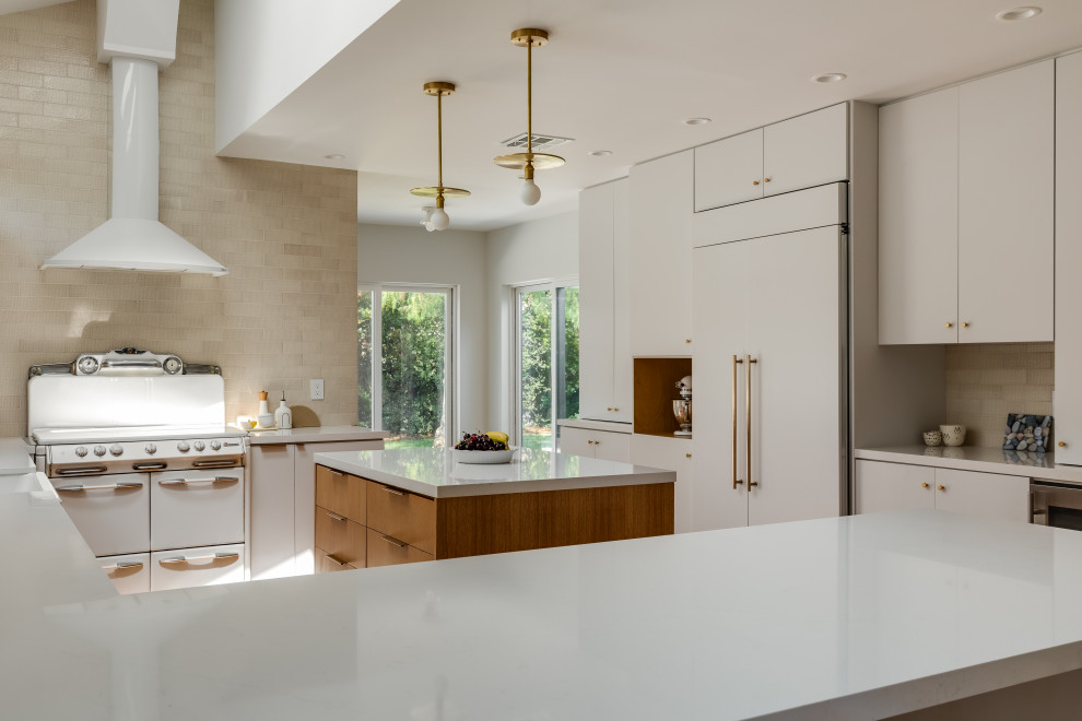 Photo of a mid-sized contemporary u-shaped eat-in kitchen in Los Angeles with an undermount sink, flat-panel cabinets, white cabinets, quartz benchtops, white splashback, stone slab splashback, white appliances, light hardwood floors, multiple islands, white benchtop and vaulted.