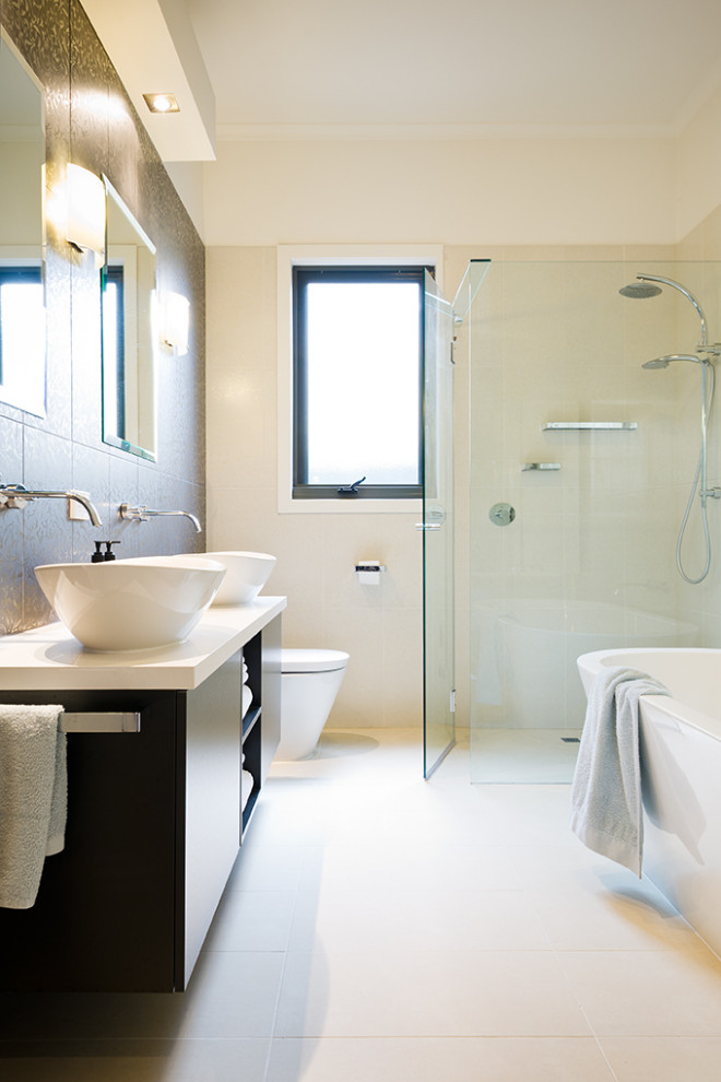 Mid-sized contemporary master bathroom in Melbourne with furniture-like cabinets, white cabinets, a freestanding tub, an open shower, a one-piece toilet, black and white tile, porcelain tile, white walls, porcelain floors, engineered quartz benchtops, white floor, an open shower, white benchtops, a double vanity and a freestanding vanity.