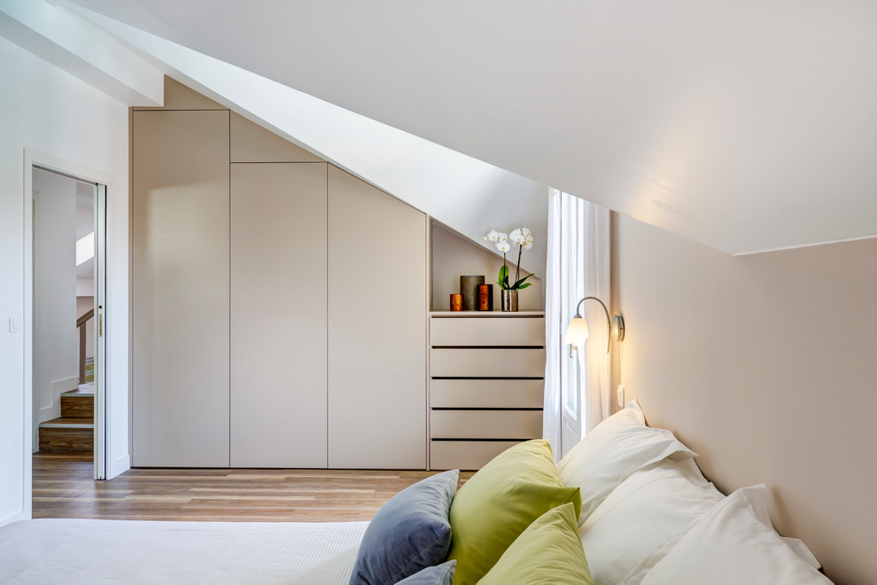 This is an example of a mid-sized contemporary bedroom in Bordeaux with white walls and light hardwood floors.