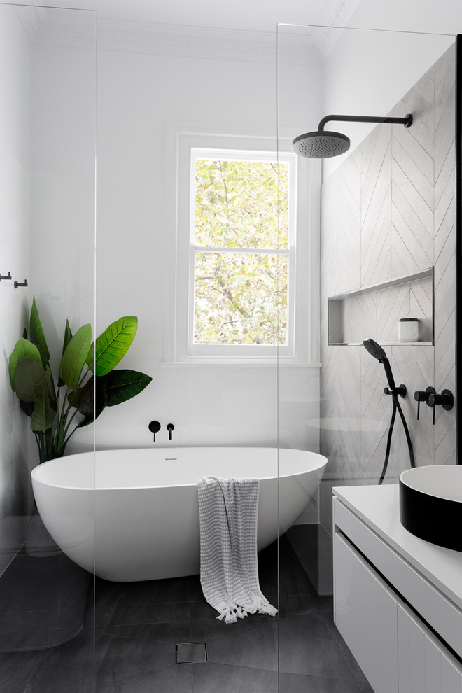 Photo of a mid-sized contemporary master wet room bathroom in Melbourne with flat-panel cabinets, white cabinets, a freestanding tub, a wall-mount toilet, white tile, cement tile, a vessel sink and engineered quartz benchtops.