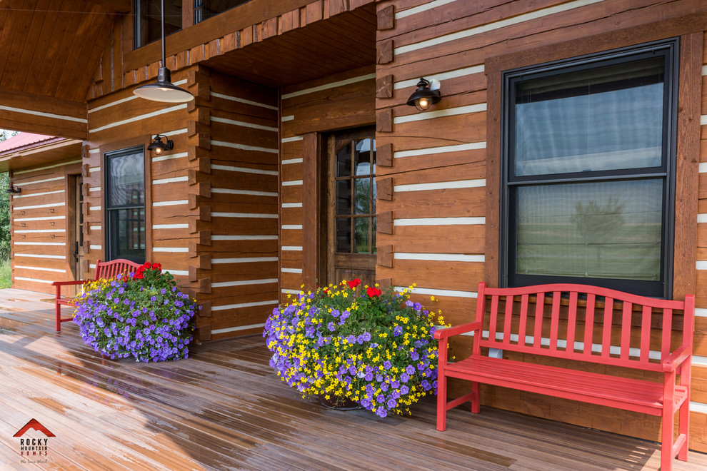 Mid-sized mountain style medium tone wood floor and brown floor foyer photo with white walls and a dark wood front door